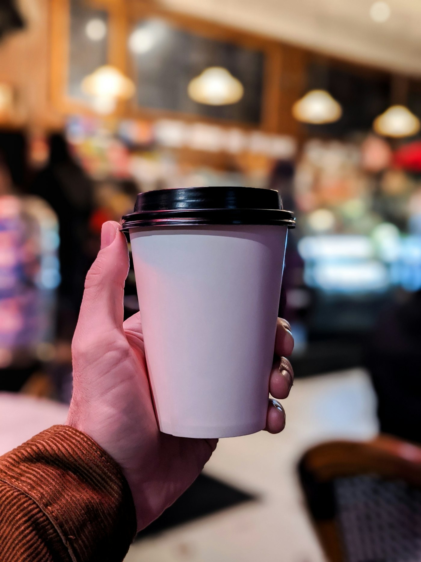 Hand holding a coffee to go